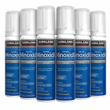 Multiple bottles of Kirkland Minoxidil Foam on a white background